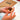 Hand holding a chocolate truffle with a chocolate box in the background
