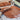 A close-up of Chocolate Workshop Masterclass dark chocolate being spread on a metal surface with a spatula, with a chocolate mold and partially set chocolate in the background, highlighting the artistry of the workshop.
