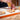 In the Macarons Masterclass, caramel-colored filling is piped onto French macarons crafted with Marou chocolate, ready for assembly on the kitchen counter.
